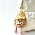 Brown ice cream cone bag charm hanging on cream canvas backpack, sleepy pouty plush keychain with corduroy legs