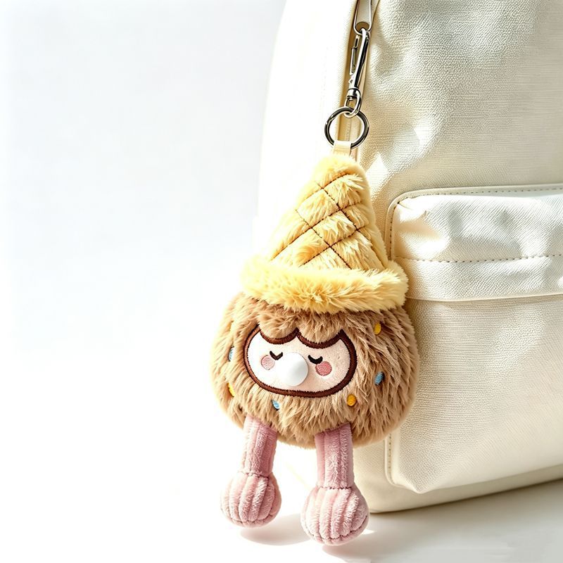 Brown ice cream cone bag charm hanging on cream canvas backpack, sleepy pouty plush keychain with corduroy legs