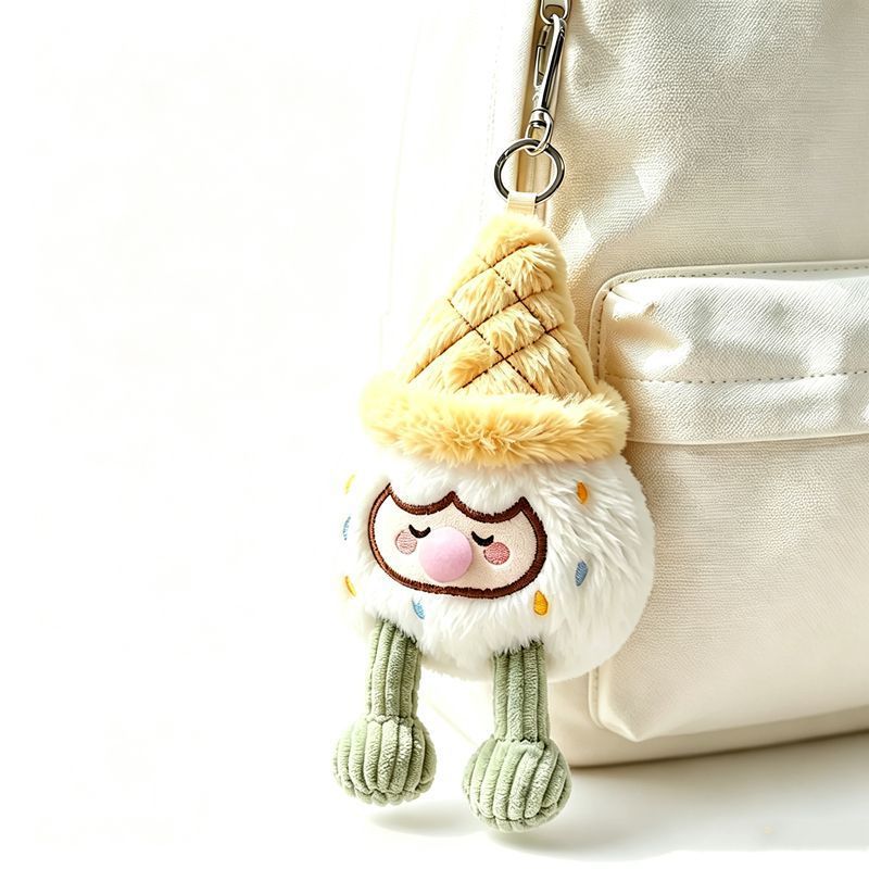 Cream white ice cream cone bag charm with pink nose and green corduroy legs hanging on tote bag zipper