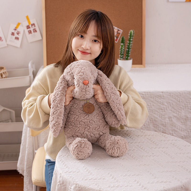 Fluffy textured stuffed bunny, brown floppy ear bunny plush held for display