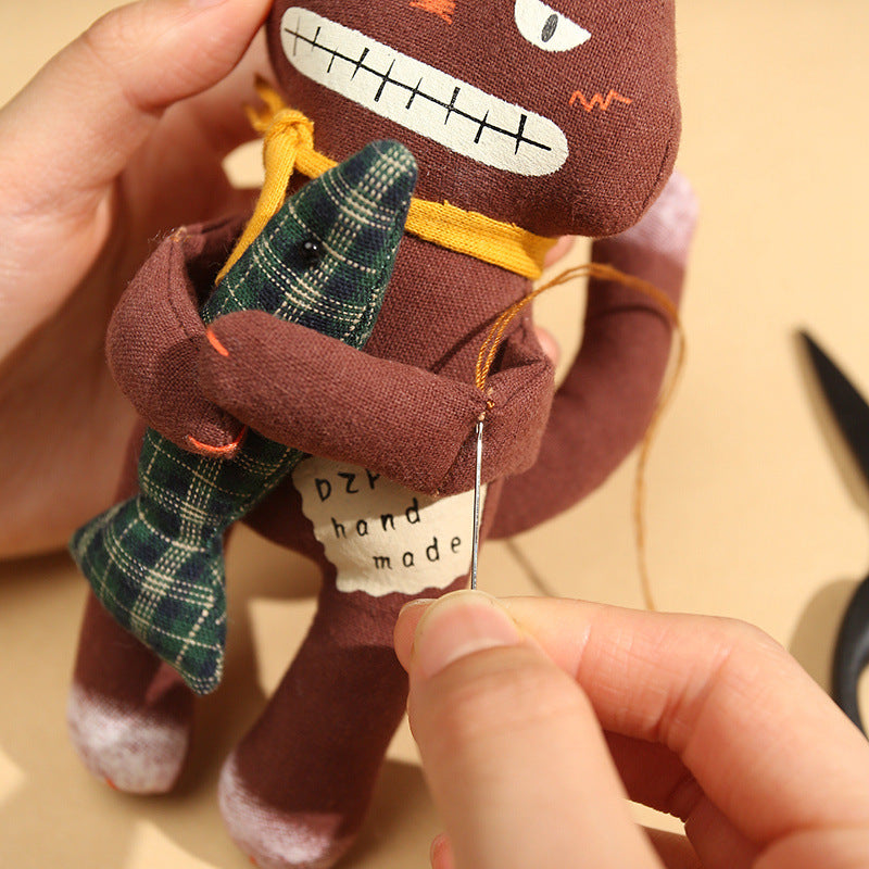 Close-up of a hand sewing details on a brown handmade black cat bag charm