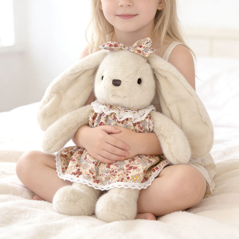 Little girl hugging a soft long‑ear stuffed bunny in floral dress, cozy kids playtime with plush toy