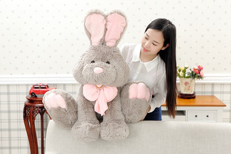 Cute gray bunny plushie held by model | soft fluffy stuffed bunny with pink bow | huggable rabbit plush toy for kids