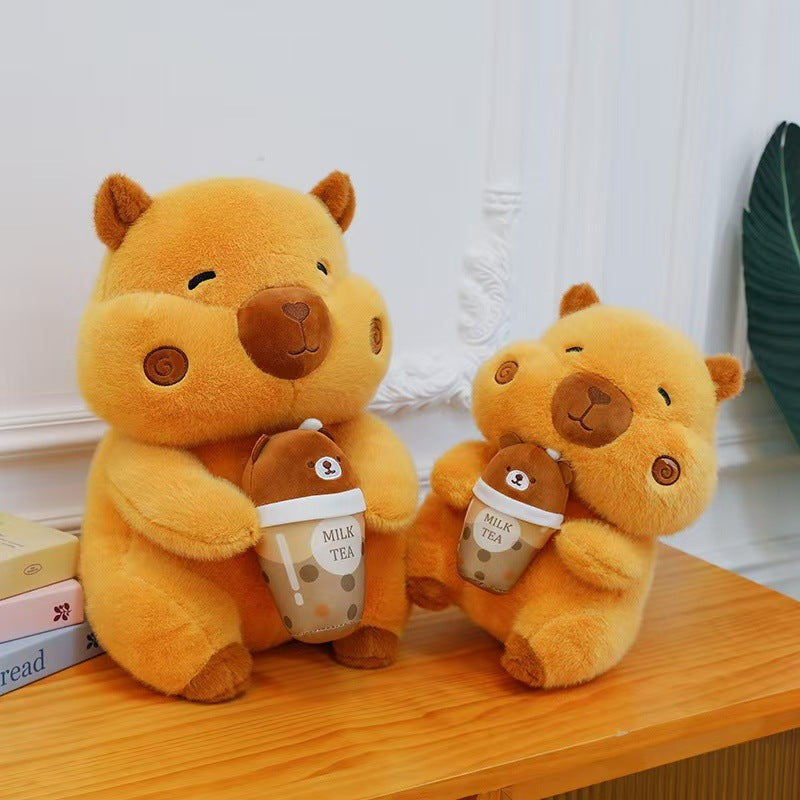 Two orange boba milk tea capybara plush toys in different sizes sitting on a wooden table