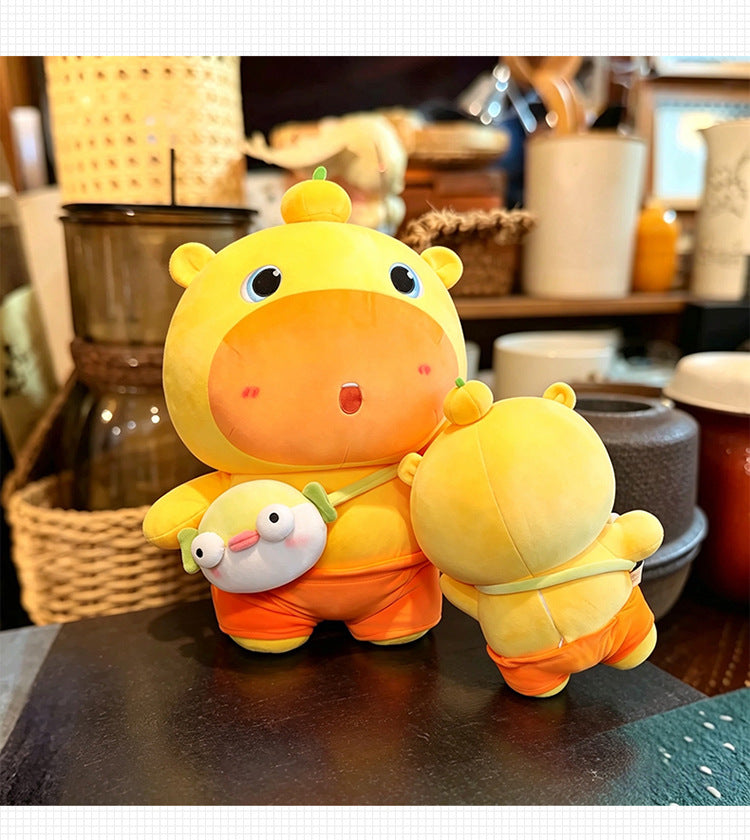 Two sizes of yellow‑orange capybara plush toys, large and small size displayed together on table