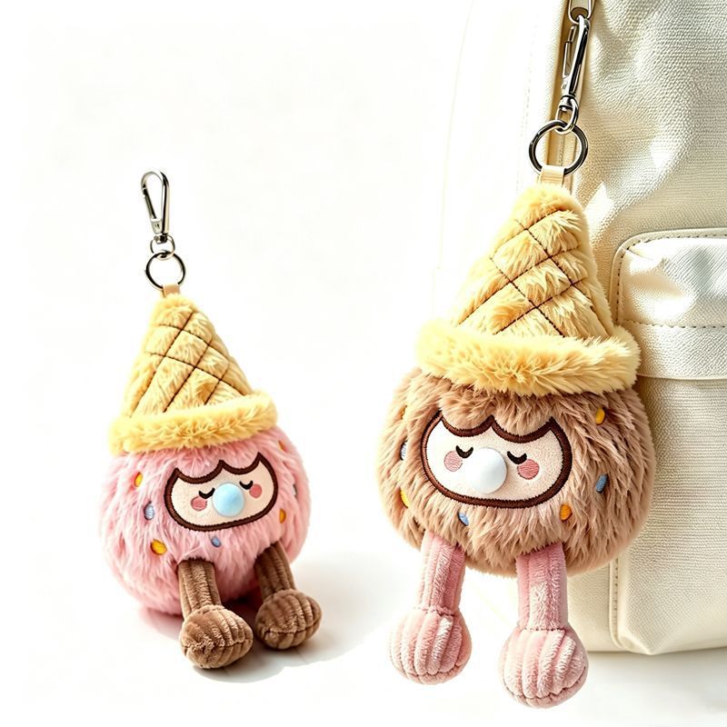 Two kawaii ice cream cone bag charms, pink and brown plush keychains hanging on white backpack, side by side