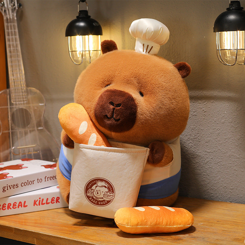 Soft stuffed bread capybara plush toy placed on a wooden desk with bakery theme decor 