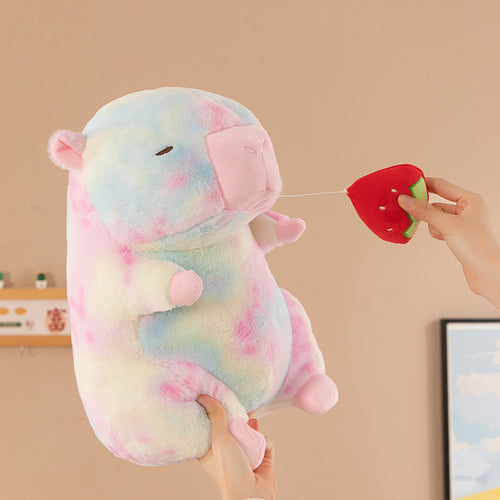 Funny tie-dye capybara plushie with a retractable pull-string strawberry being stretched