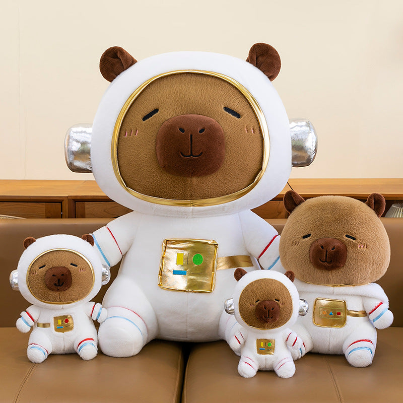 A collection of space astronaut capybara stuffed animals in giant, medium, and mini sizes on a sofa