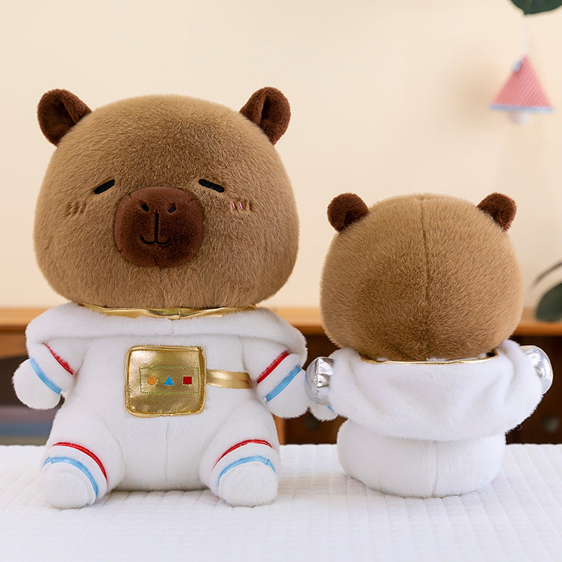 Front and back view of the space suit capybara plushie showing its soft white hood and silver details