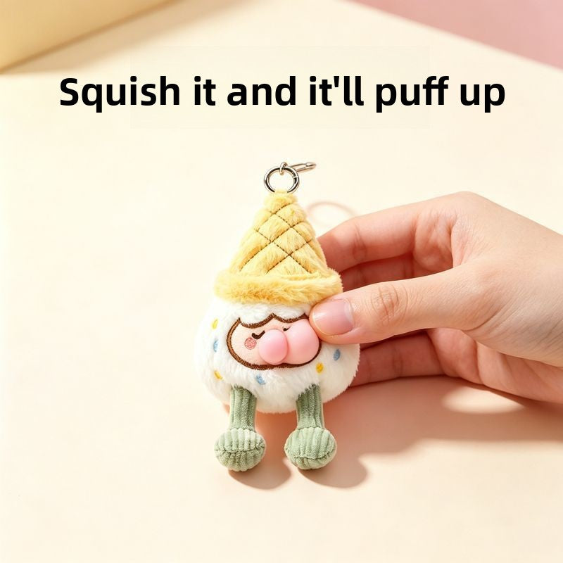 Hand squeezing white squishy ice cream cone plush keychain, stress relief fidget toy with pink pouty bubble nose
